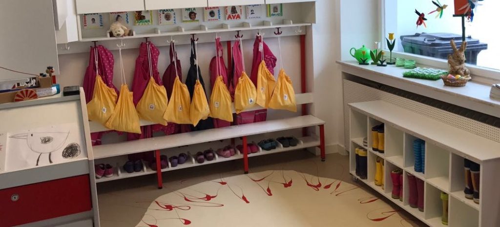 Garderobe mit Turnbeuteln, Hausschuhen, Regenjacken und Gummistiefeln